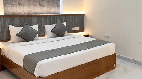 View of a bedroom featuring a double bed and a wall-mounted mirror | Hotel Aurora Bliss