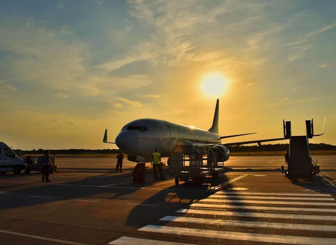 An aeroplane parked on the runway with steps positioned for boarding.
