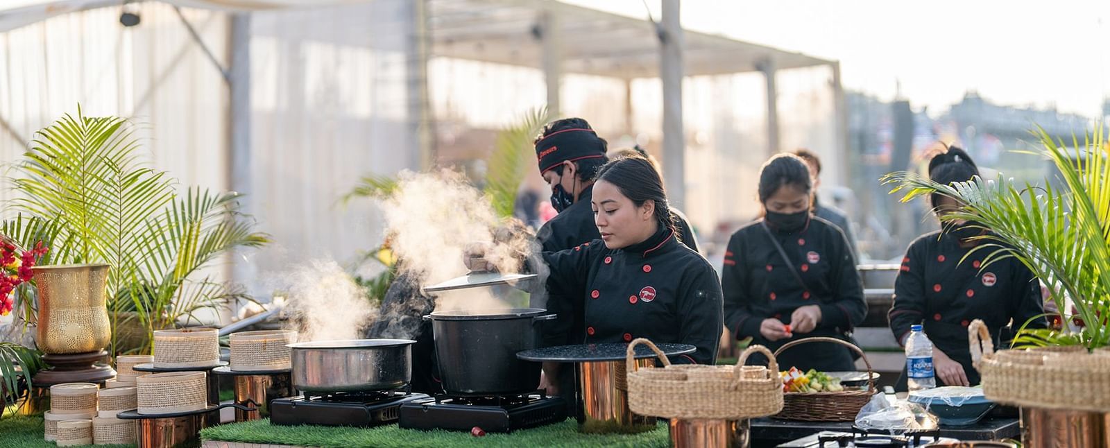 Chefs preparing a meal in an open air setting at Nirvana Luxury Hotel, Ludhiana.