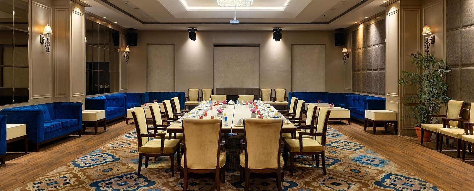 A meeting hall with chairs placed facing a huge table at Nirvana Luxury Hotel, Ludhiana.
