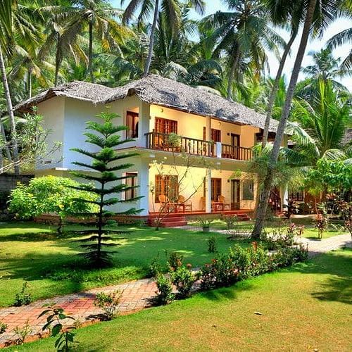 Facade image of Abad Harmonia, Kovalam in front of a garden surrounded by many trees