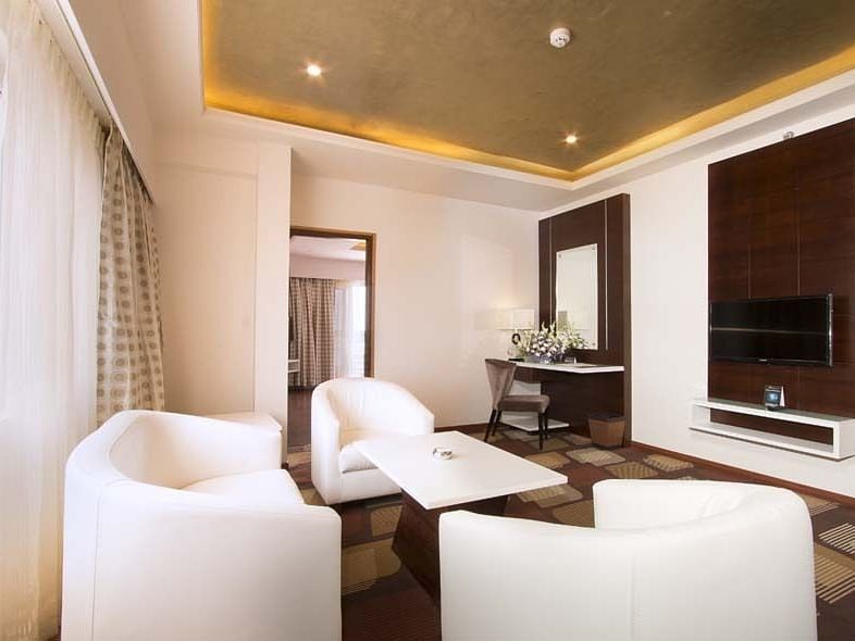 An image of a bedroom featuring sofa sets and centre table - Pai Group of Hotels