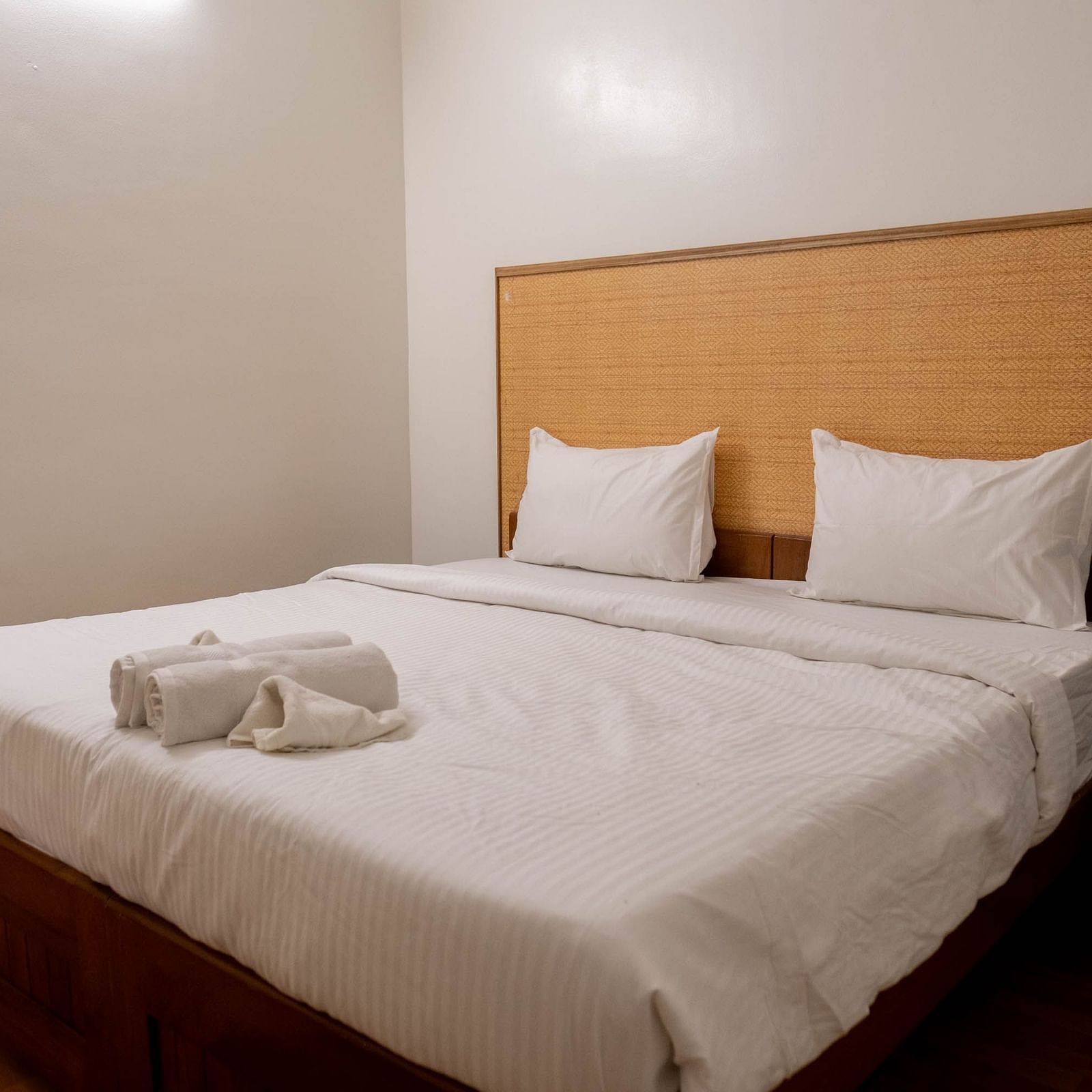 Side veiw of a bed with towels at 1 bhk Deluxe Studio Apartment, Vistar Holidays, Goa.