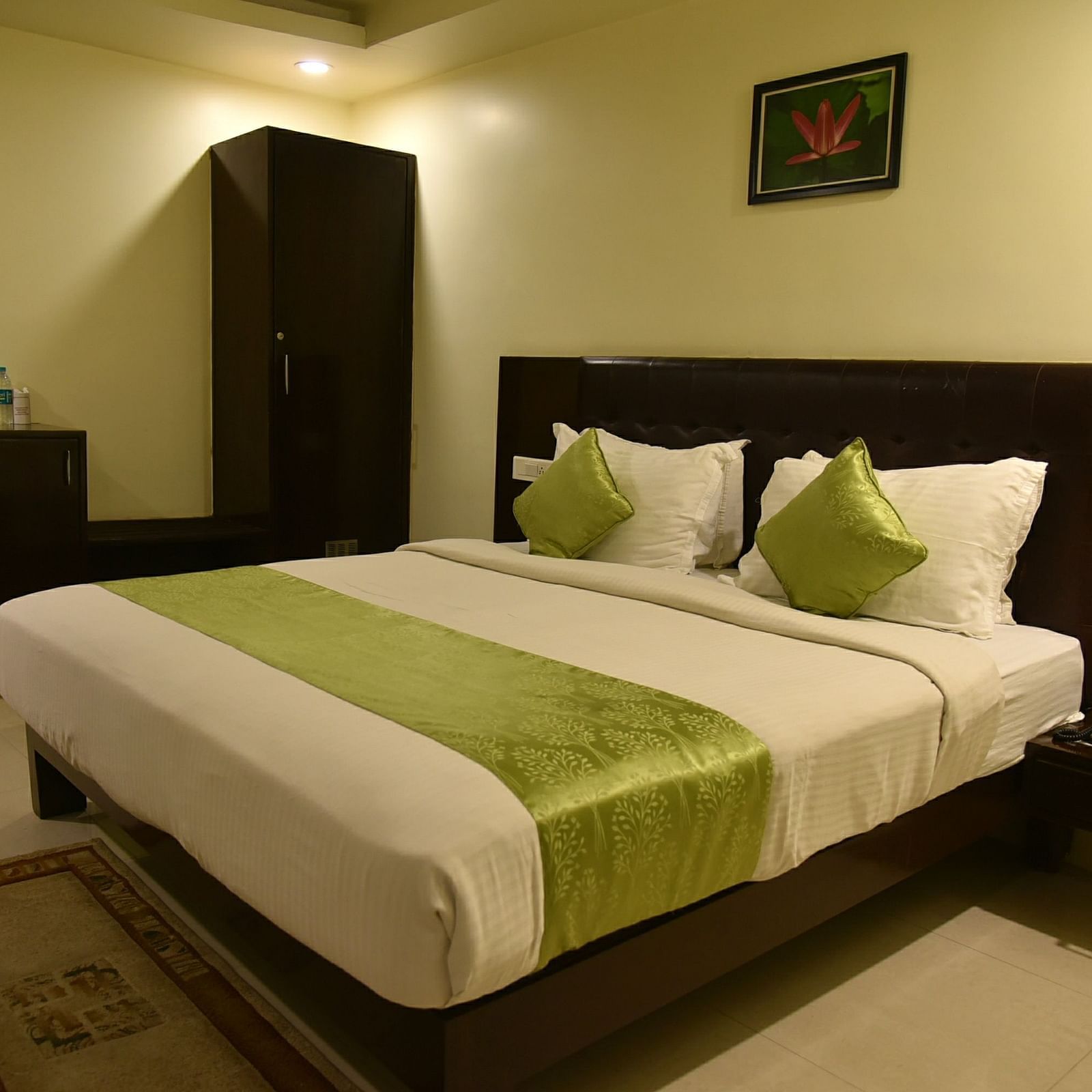 Room with bed, wardrobe and side table at Hotel Green Apple