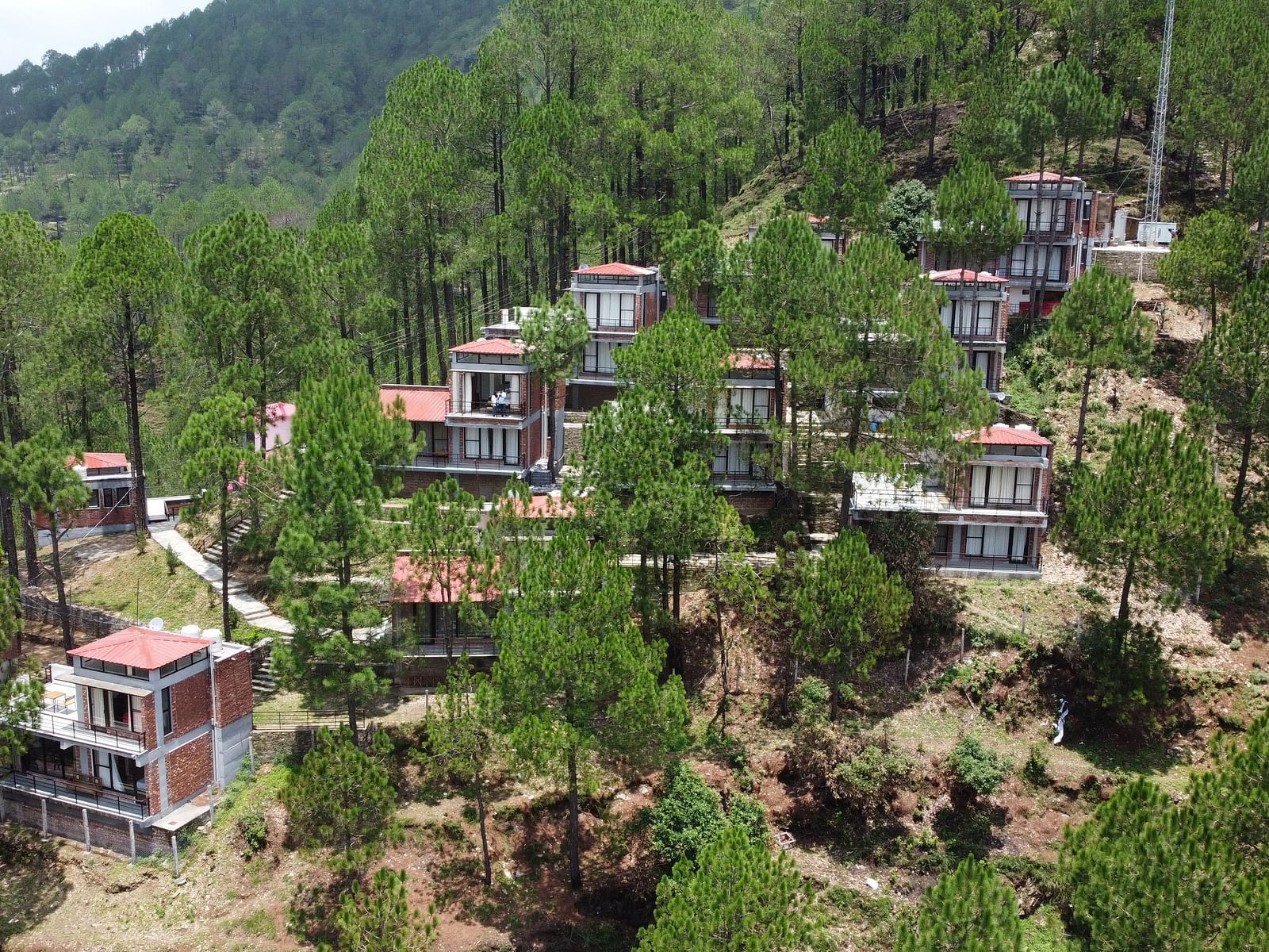 aerial view of the BluSalzz Escapade Resort, Lansdowne surrounded by green trees.