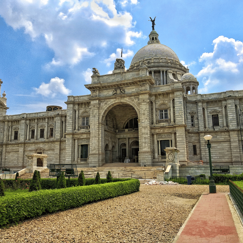 The pathway to the Victoria Memorial surrounded by lush well manicured lawns.