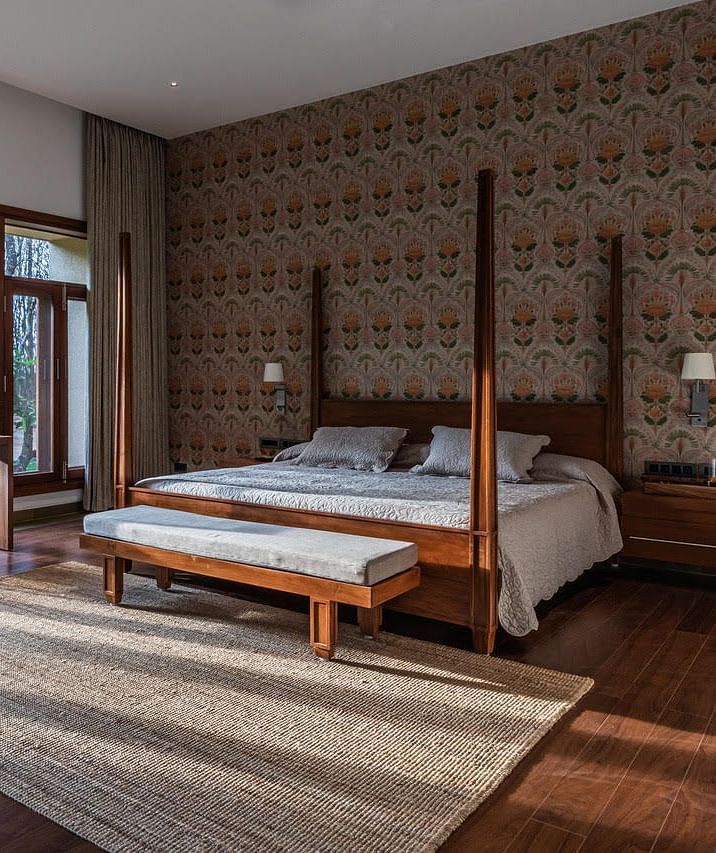 A bedroom with a four-poster bed, large windows, and a brick wall, modern design - Shreyas Retreat