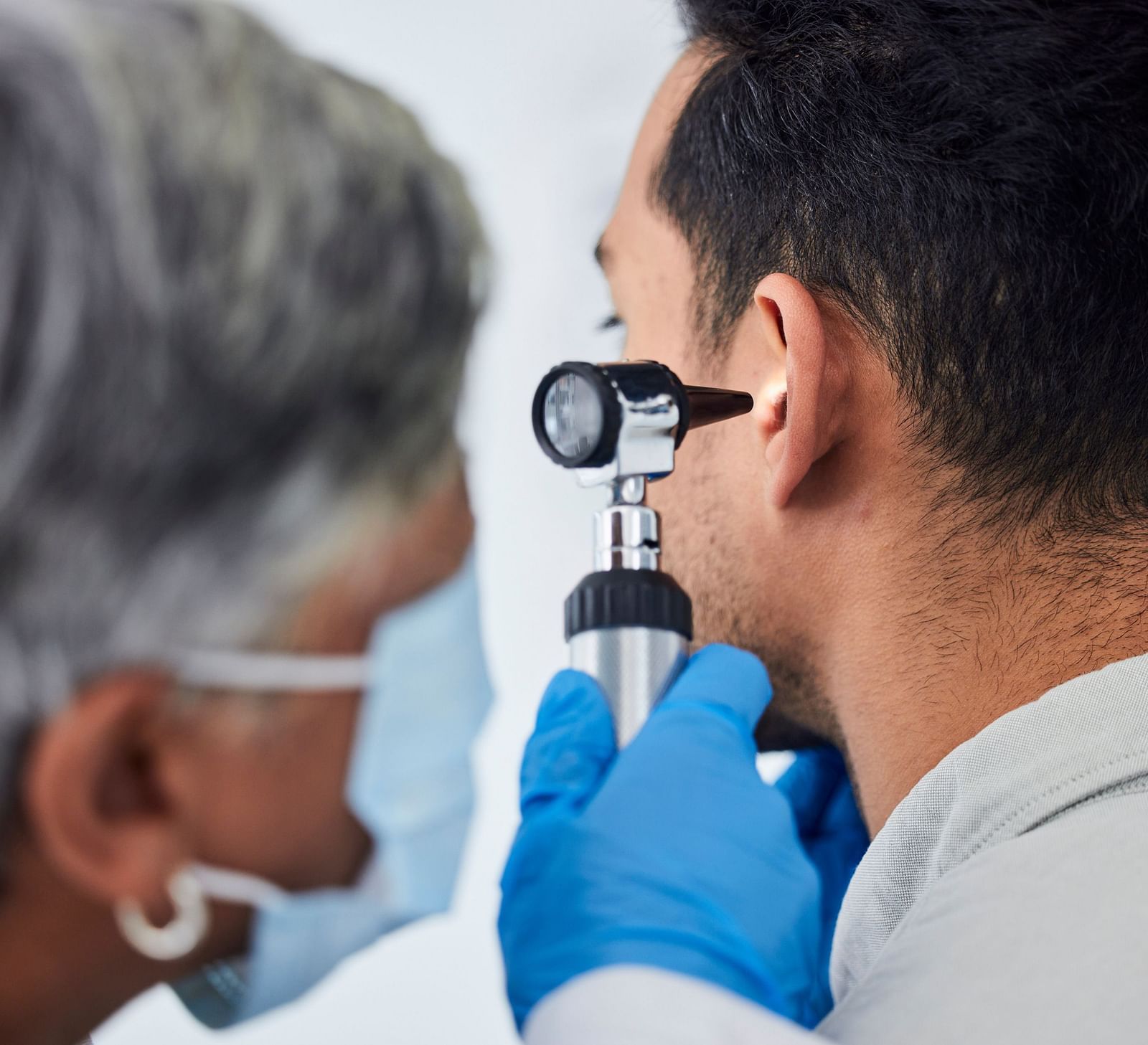 A doctor using an otoscope to examine a patient’s ear - Shreyas Retreat