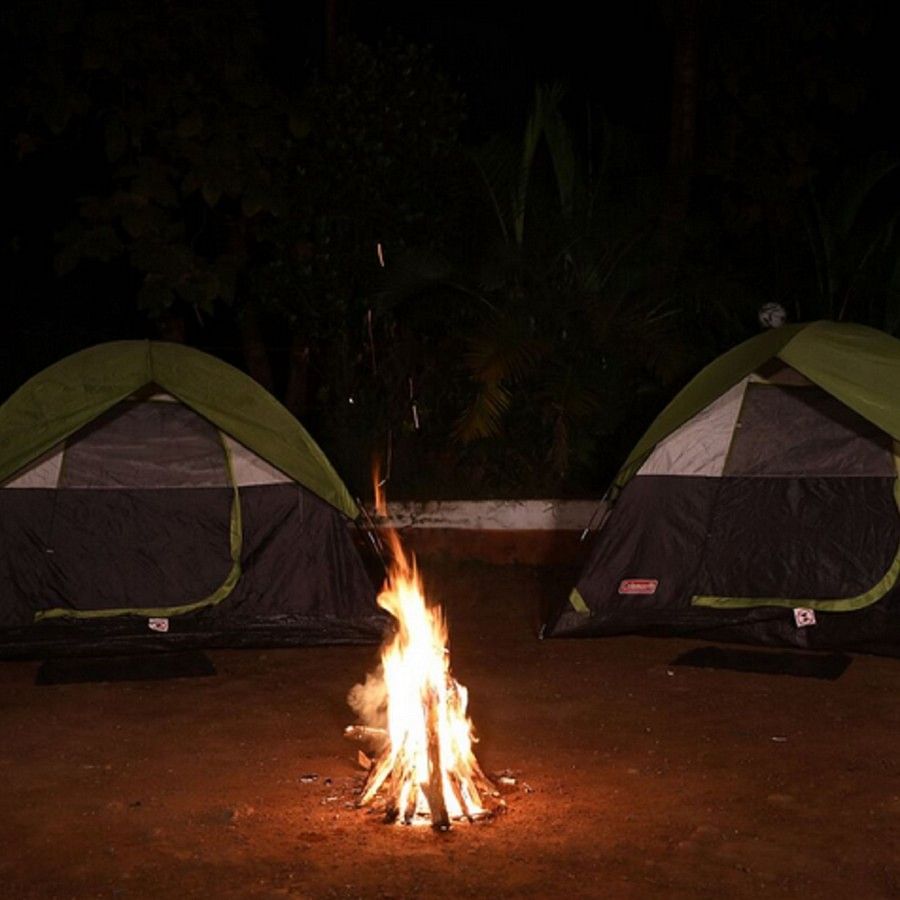 Two tents with campfire in the middle, during the night