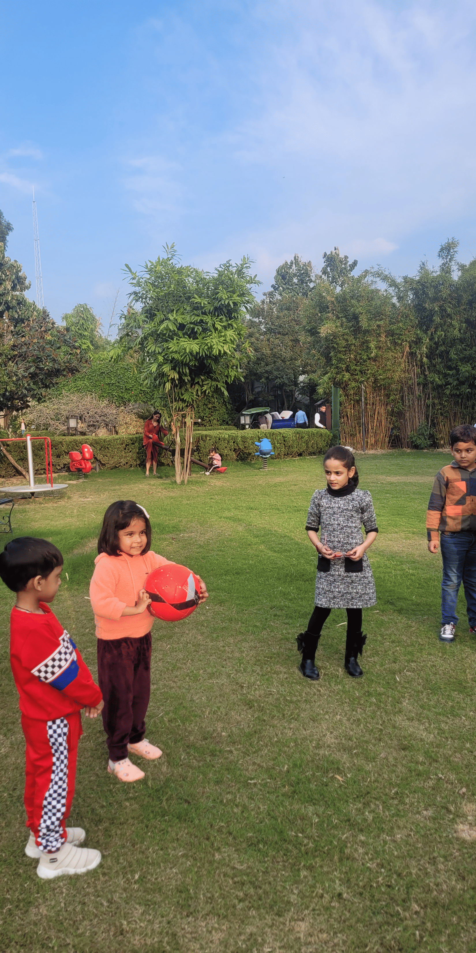An outdoor scene with several people gathered on a green lawn