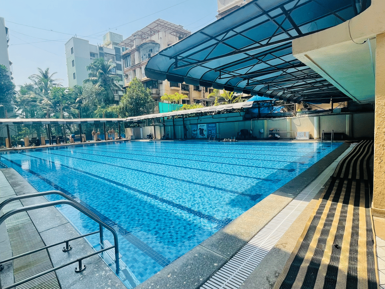 Home2 Renaissance Club Hotel, Andheri West swimming pool area with lounge seating and modern surroundings.