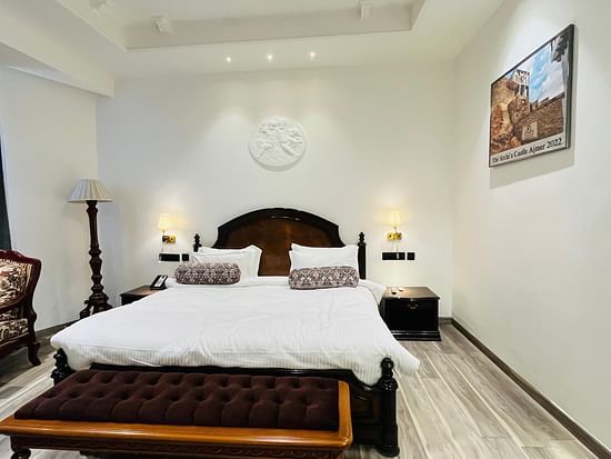 an image of a bedroom with a chair and a painting at Clarks Resort The Archi’s Castle, Ajmer