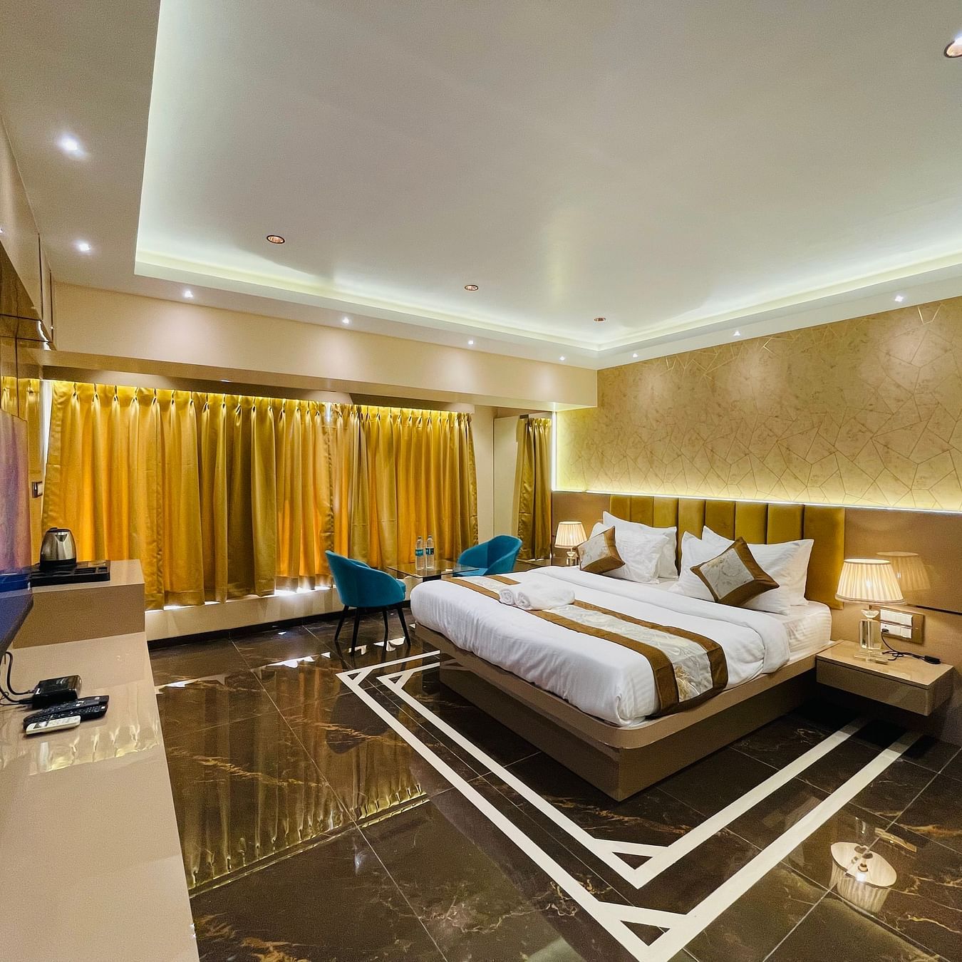 A king bed next to sofas inside Suite - Home2 Renaissance Club Hotel