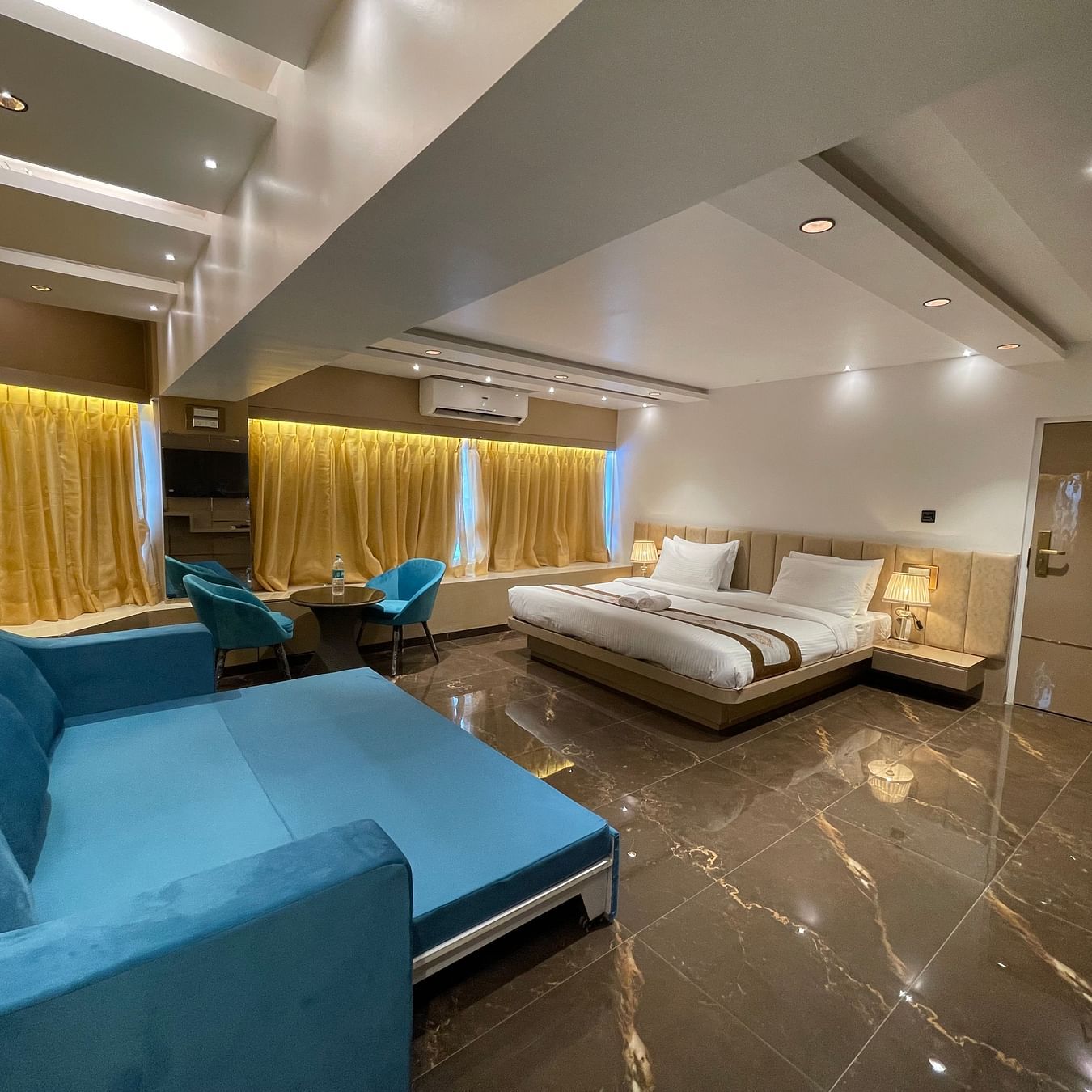 Side view of the sofa bed opposite the king bed inside Executive Suite - Home2 Renaissance Club Hotel