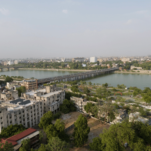 An aerial view of a river flowing the city landscape with a bridge connecting the 2 sides of the river banks.