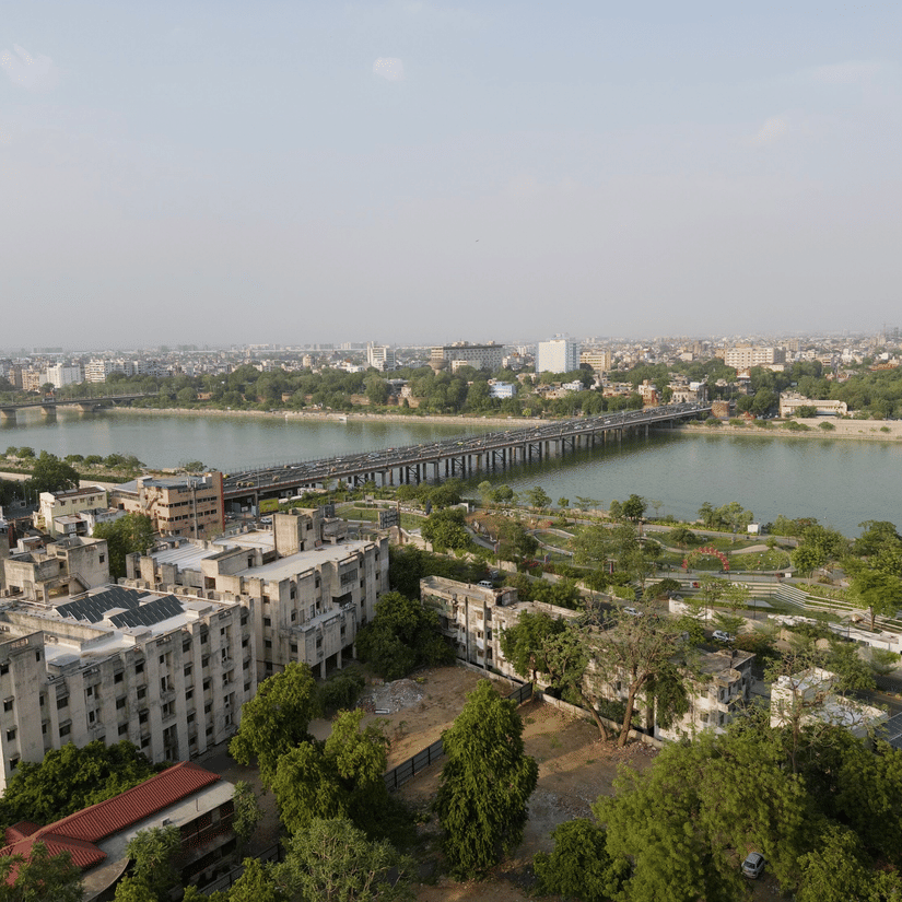 An aerial view of a river flowing the city landscape with a bridge connecting the 2 sides of the river banks.