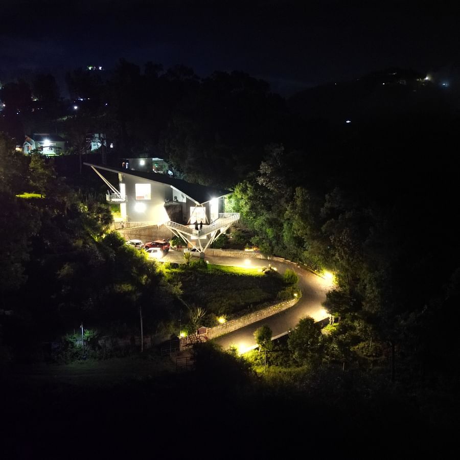 Night-view of a villa situated in a forest featuring well build roads, and warm lighting at Ibex Resorts, Coonoor (Tapas).