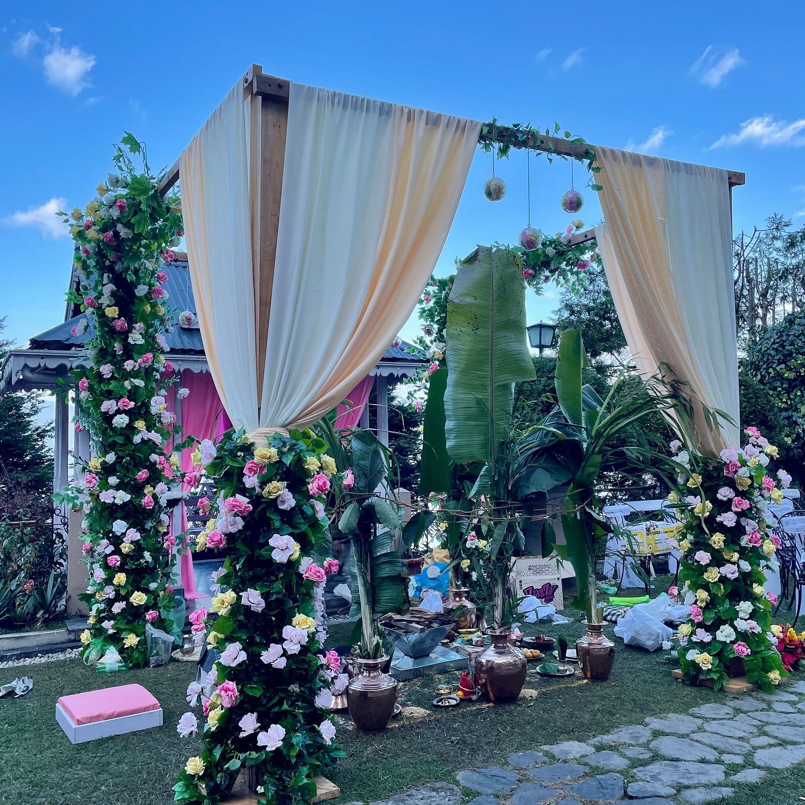 Outdoor mandap arrangement at Cedar Inn, Darjeeling, set on the lawn with mountain views and floral arch backdrop.