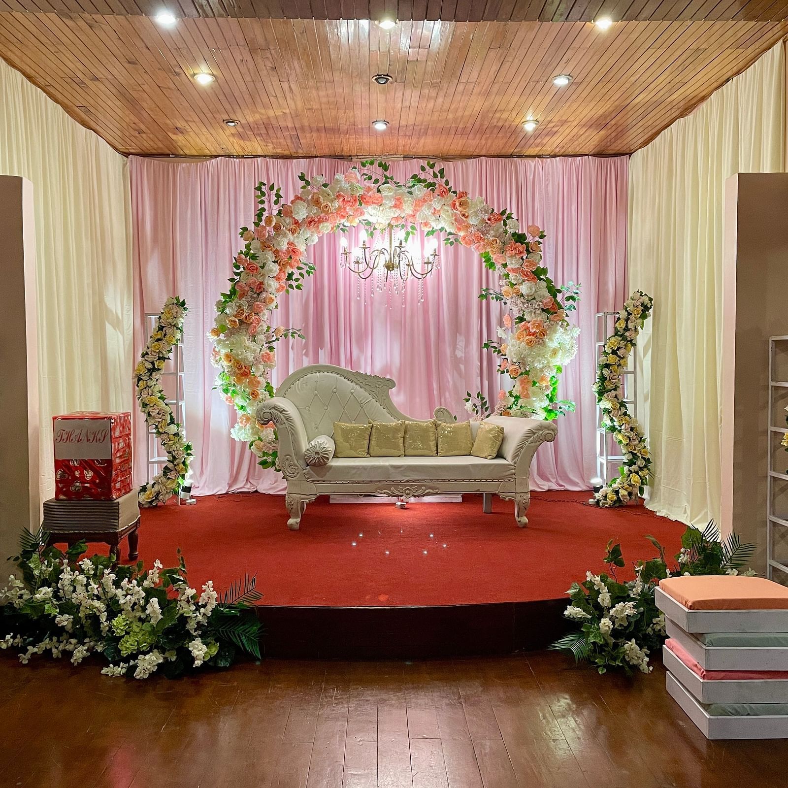 Indoor wedding stage setup at Cedar Inn, Darjeeling, with floral arch, stage seating, and draped backdrop for ceremonies.
