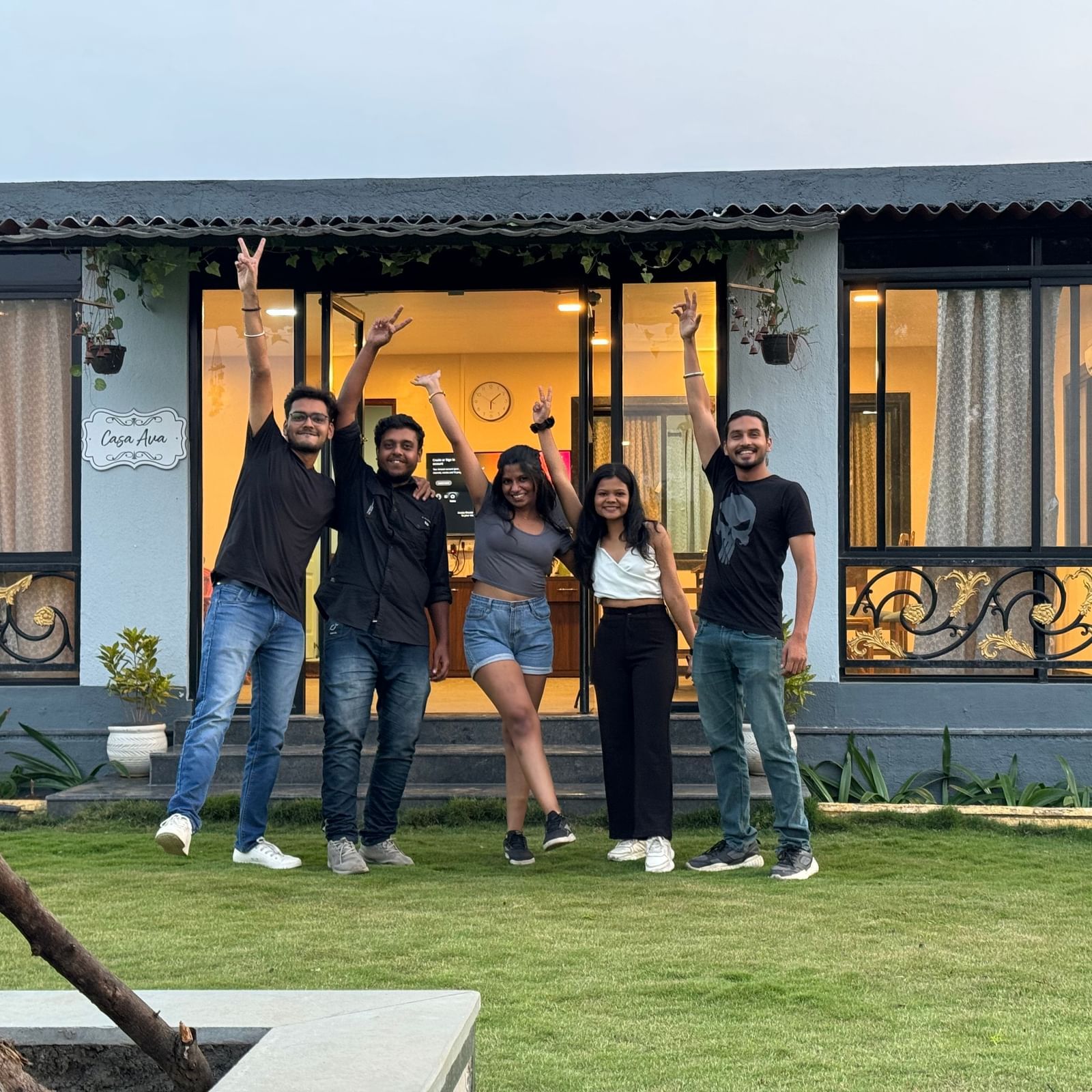 Group of friends posing joyfully in front of a hostel at sunset | Diamond Parks, Pune.