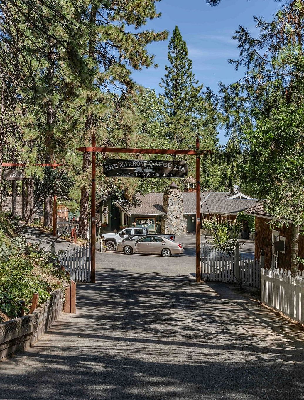 A road lined by trees leading to Narrow Gauge Inn.