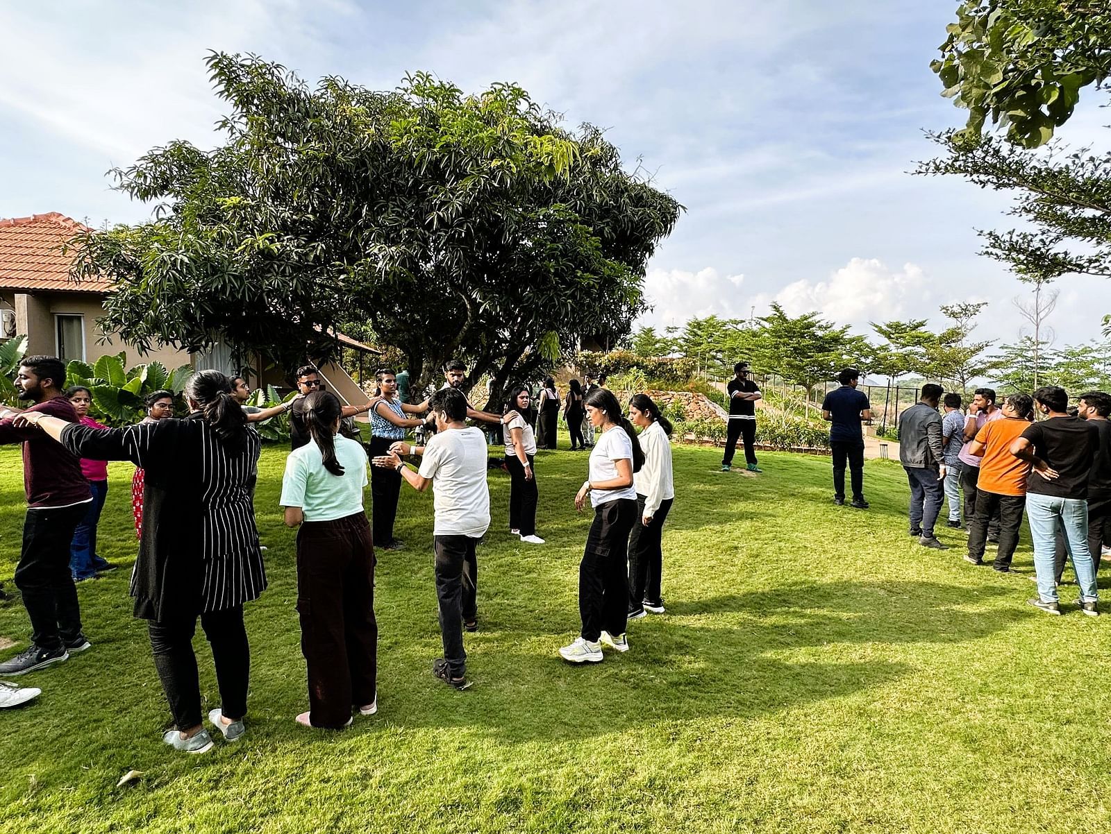A group of people at Ravishing Retreat invested in group activities outdoor on a sunny day on the lawn
