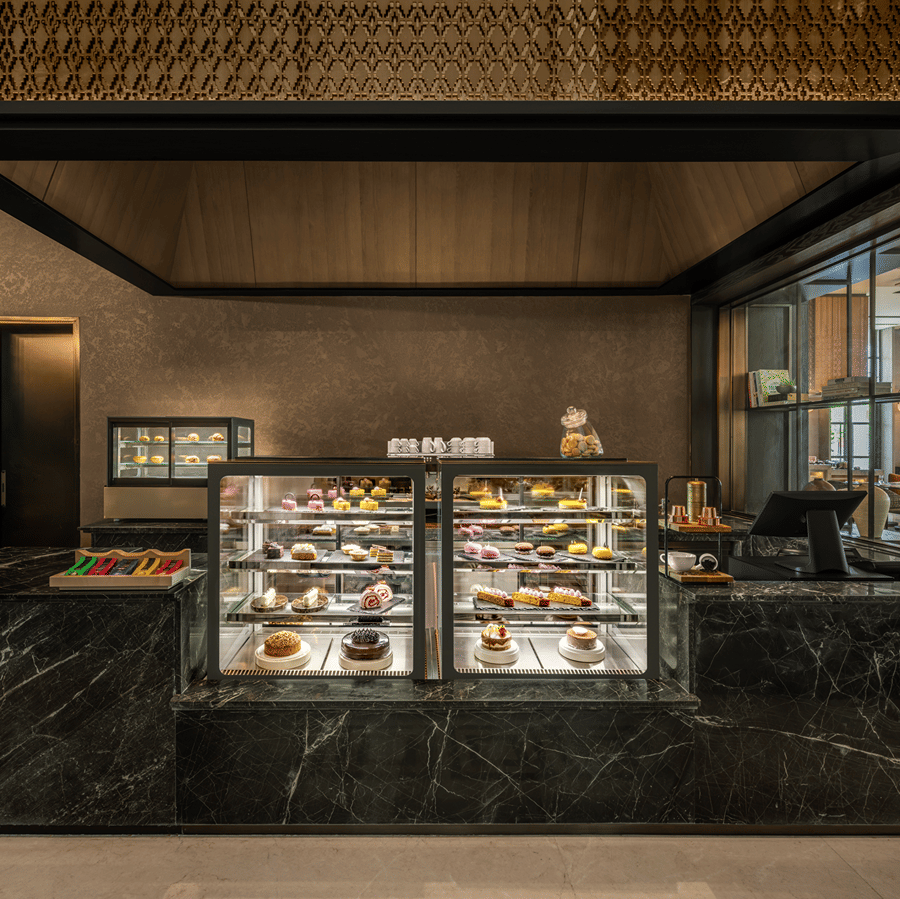 Krave counter with a glass display case and dark toned decor at The Residency Signature Madurai.