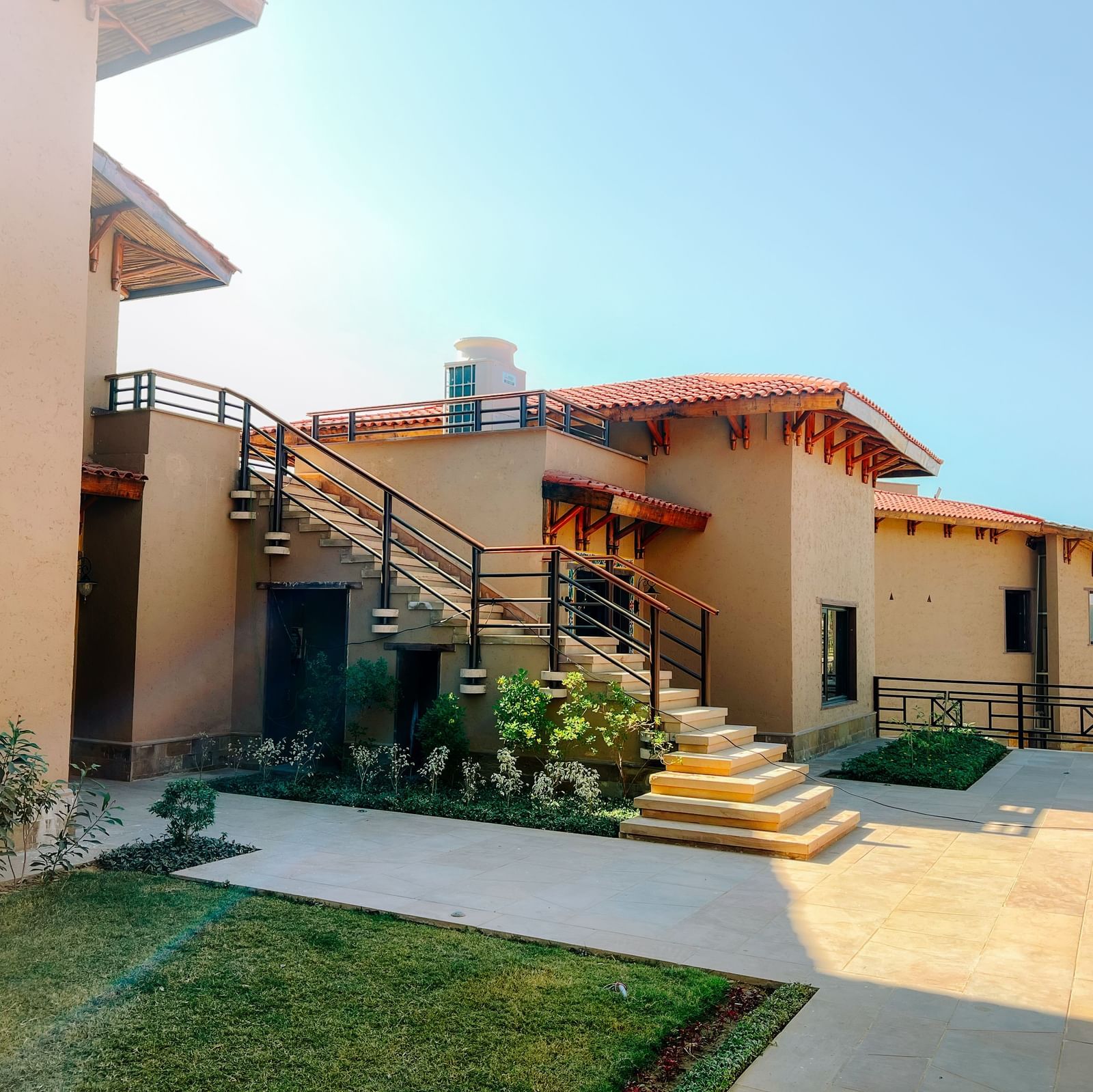 A cluster of beautifully designed resort buildings with outdoor staircases at Aamaghati Wildlife Resort.