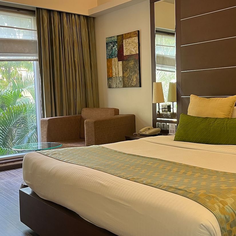 a posh bedroom with luxurious interior along with king size bed soft pillows white linens and the room also features a ceiling-to-floor windows1