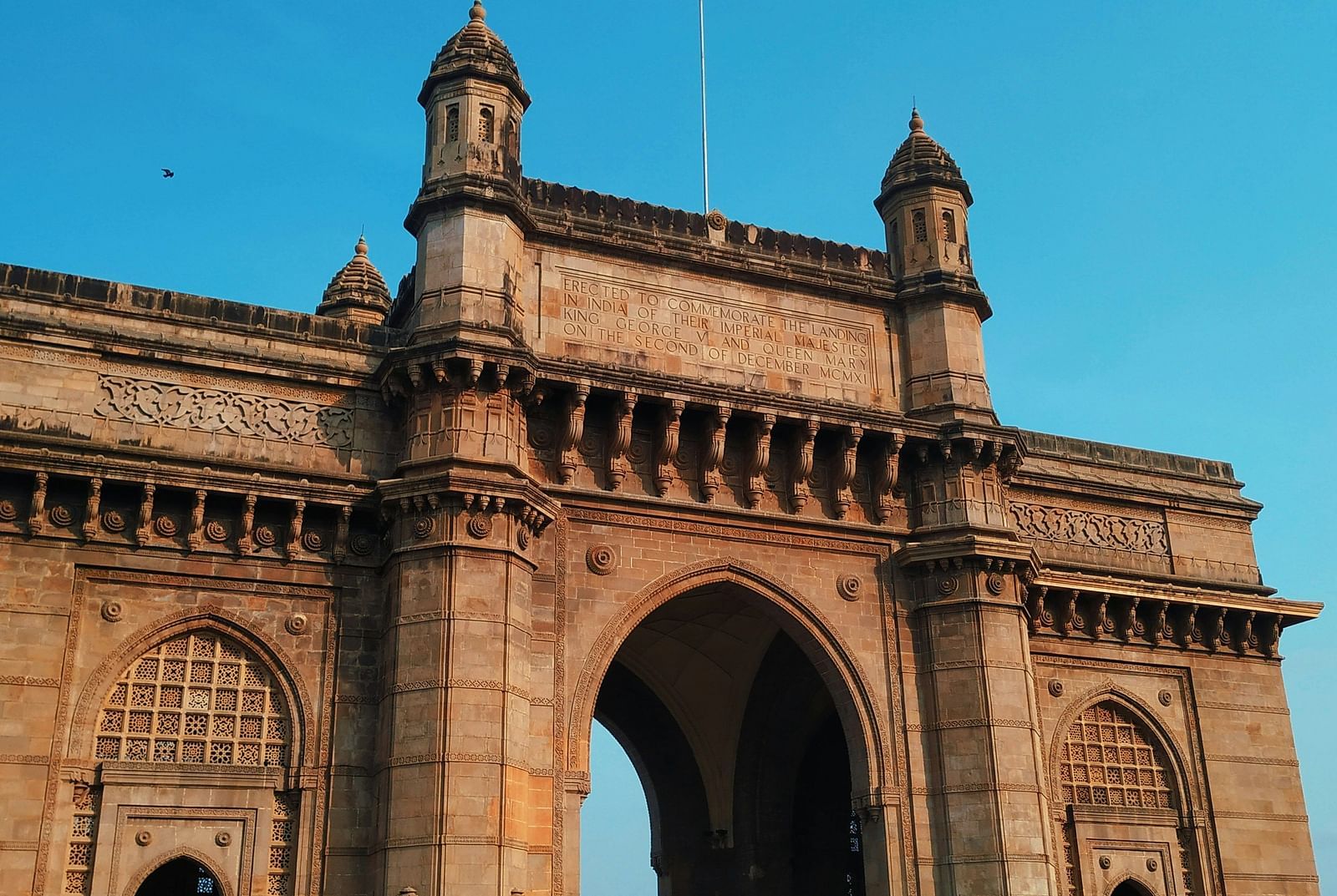 a close up image of the gateway of India with blue sky in the background