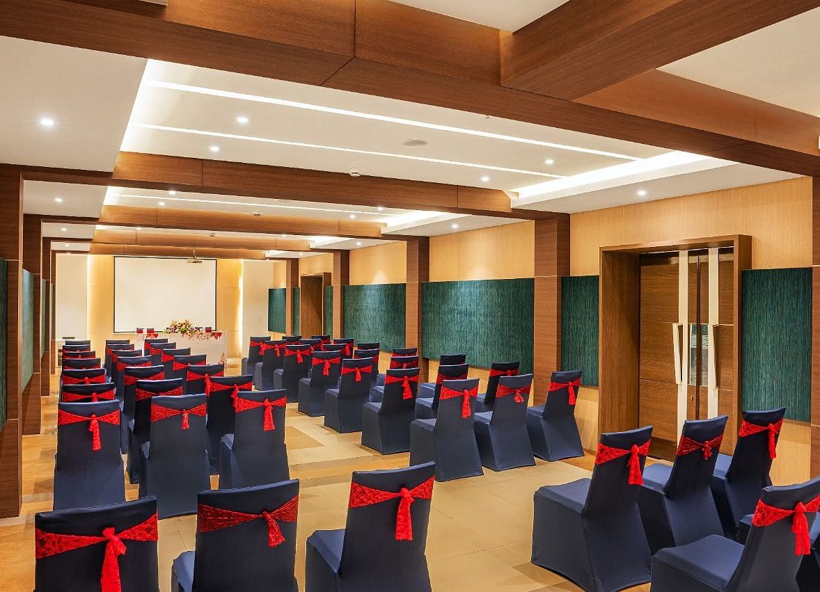 An image of huge wooden ceiling  hall with well arranged chairs at Grand Kakinada by GRT Hotels
