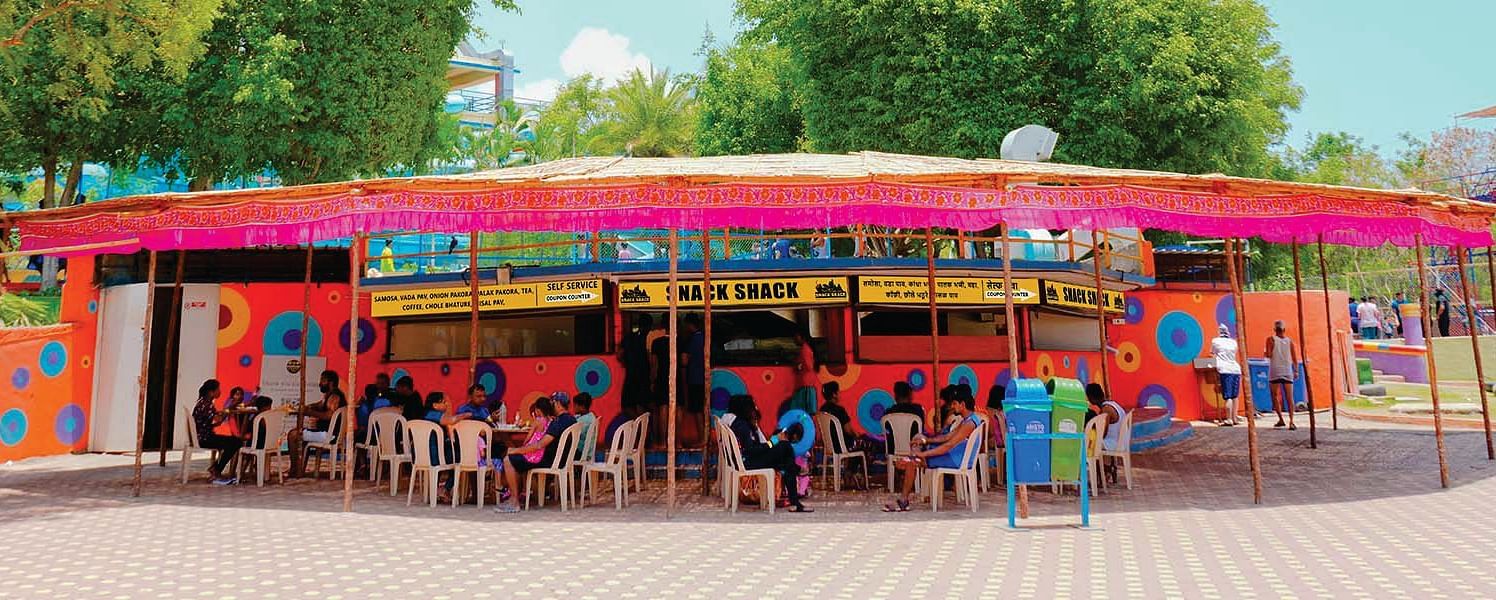 Street Food Eatery with Colorful Canopy and Seated Patrons in Urban Setting | Diamond Parks, Pune 