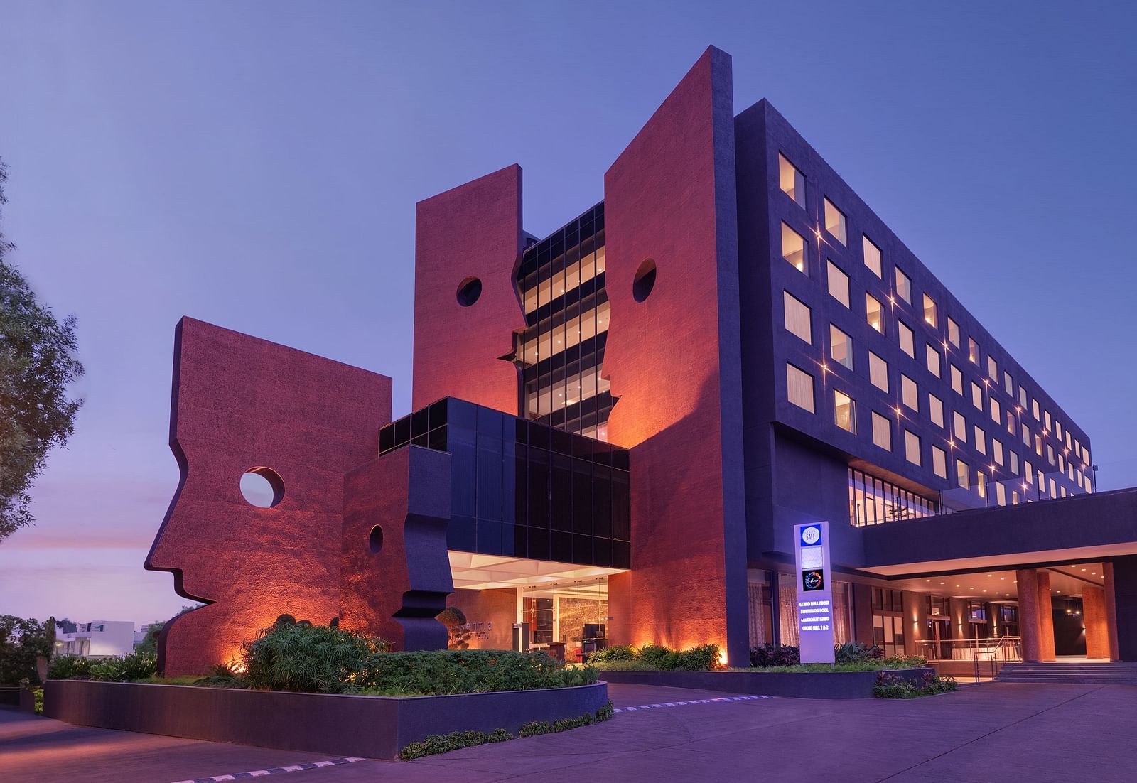 Far out view of Essentia Luxury Hotel, Indore during blue hour with the lights on.
