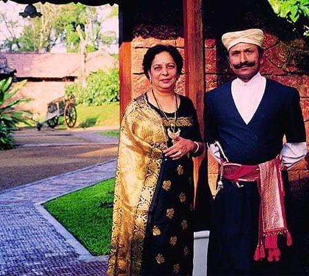 A Kodava couple in traditional attire standing near a pathway.