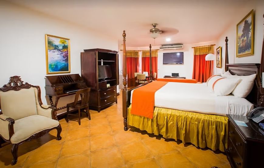 tiled bathroom shows a bathtub, a vanity with two sinks, and a walk-in shower | Alexander Suite | Altamont Court, Jamaica