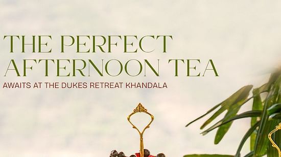 Afternoon tea setup with elegant teapots, cups, and a three-tier stand filled with colorful macarons, pastries, and savory treats at The Dukes Retreat Khandala