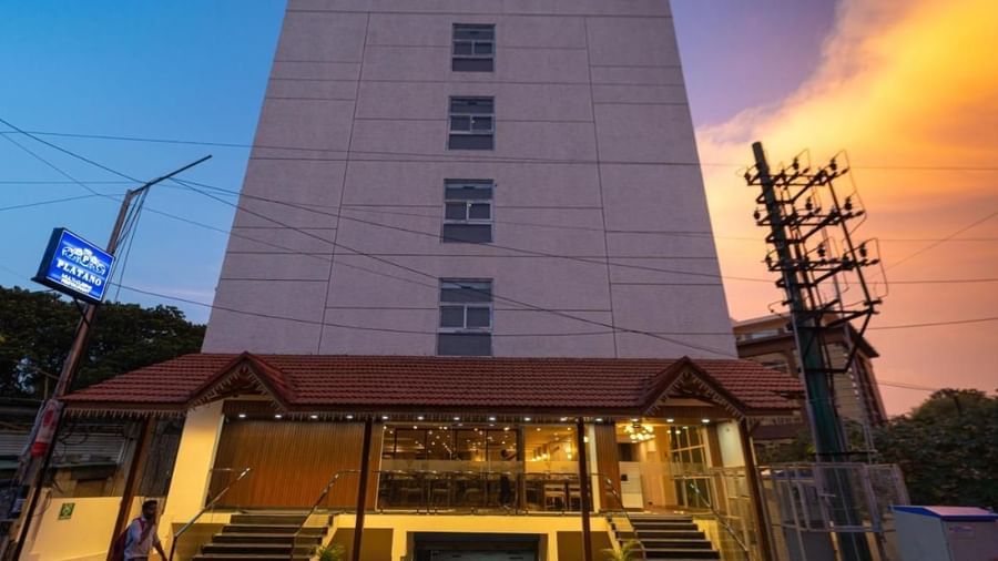 The facade of VITS Select, Bengaluru as seen from the front, featuring stairs leading up to the hotel with a vibrant sky in the background.