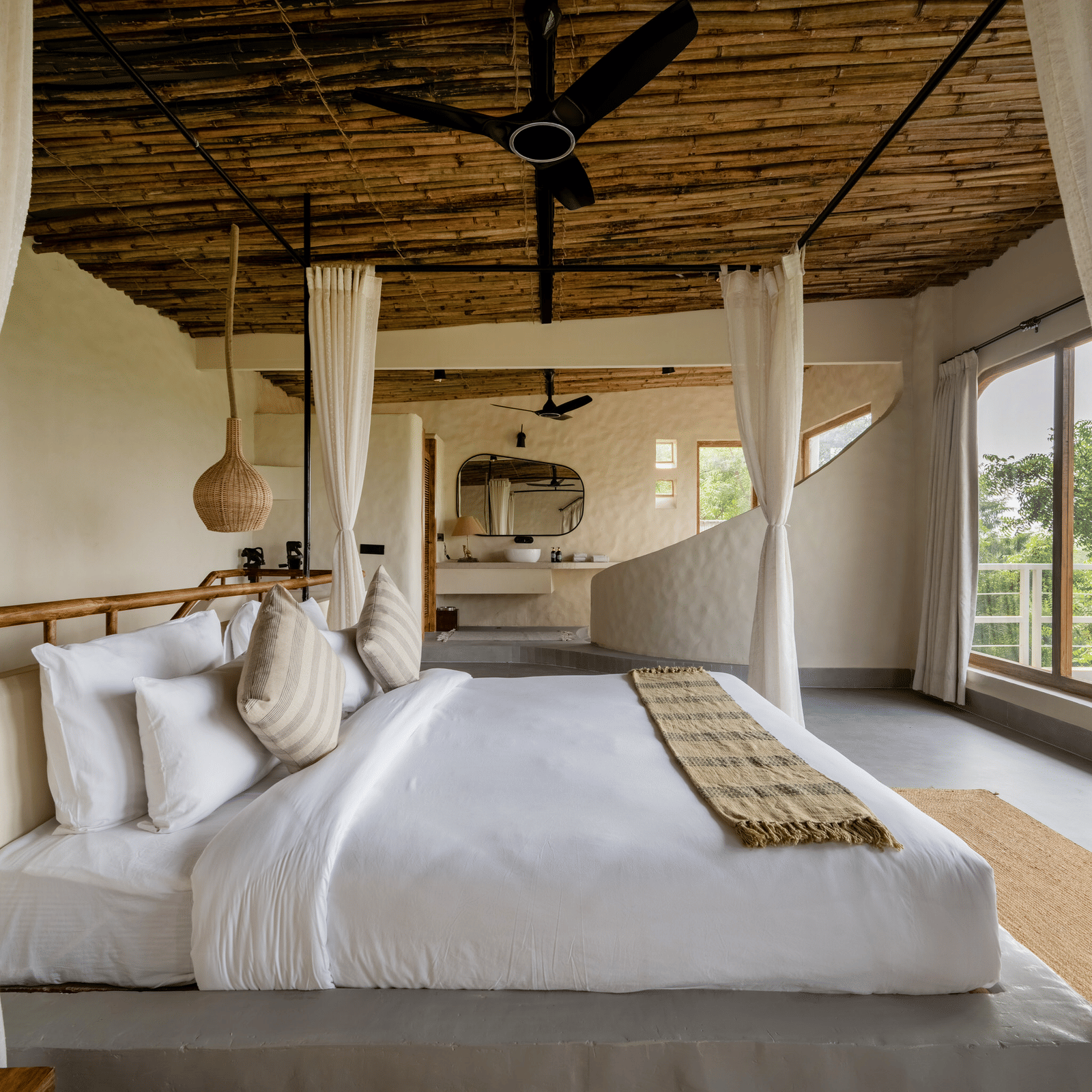 Bedroom with canopy bed, large windows, wooden ceiling, and serene outdoor views.