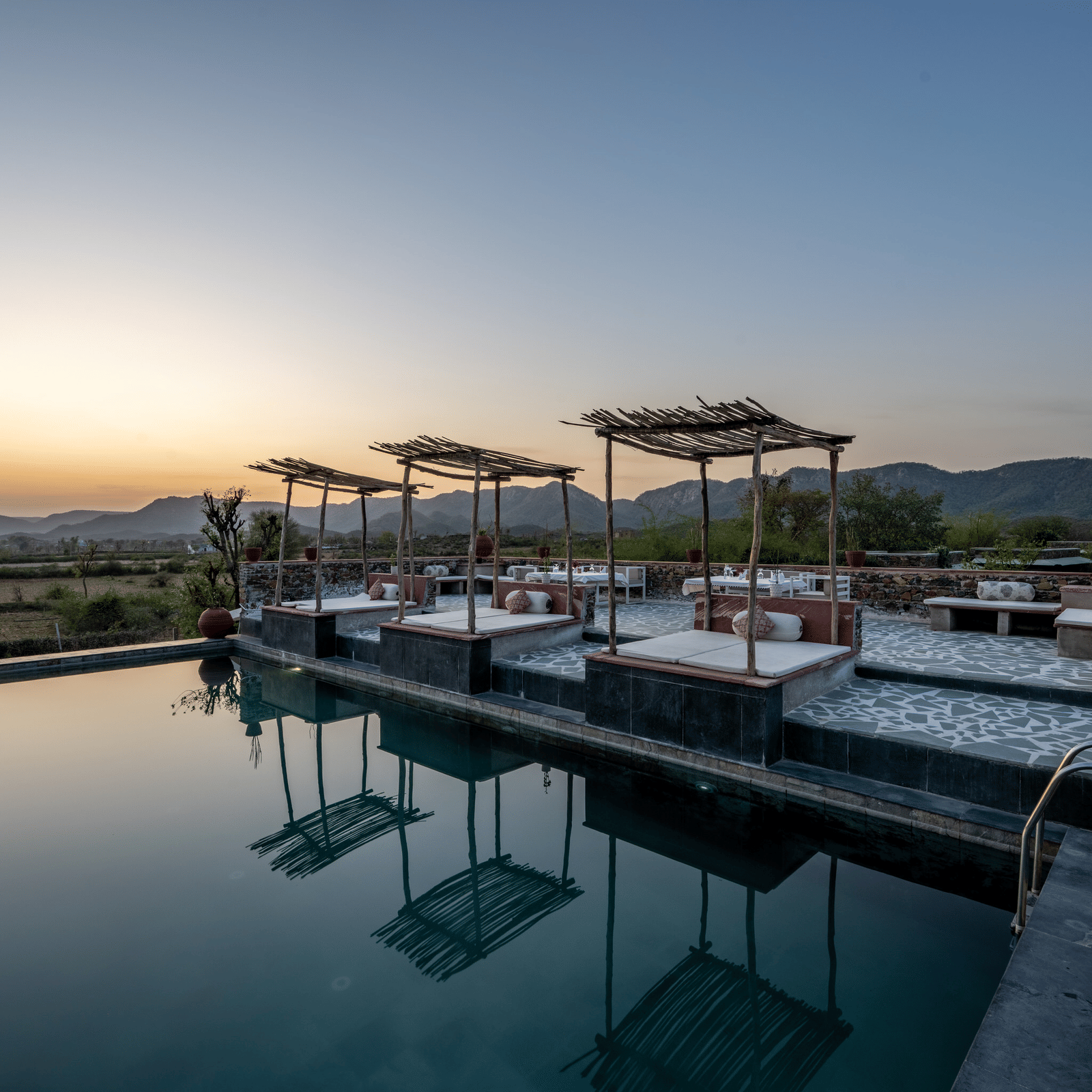 An image of a seating arrangement near the swimming pool in the open - Utsav Camp Sariska