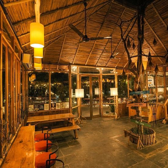 An interior space with warm lighting, featuring wooden elements and seating.