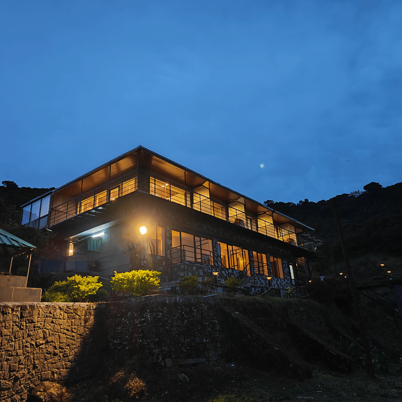A night view of the facade of the resort with blue sky in the background | Ibex Stays and Trails