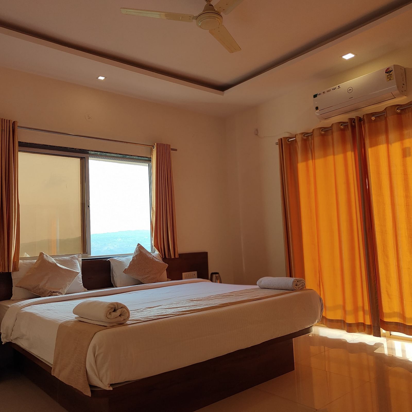 Superior Valley View Room with a large bed, orange curtains, and a window with a view.