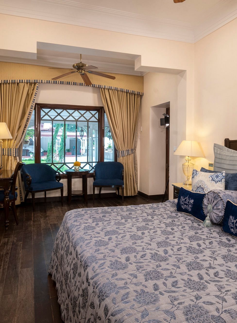 view of the king sized bed and the TV with the seating area near the window at the Claridges Nabha Residence, Mussoorie