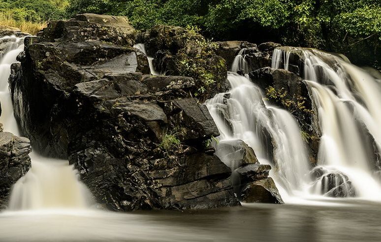 Long exposure waterfall cascading over dark rocks.