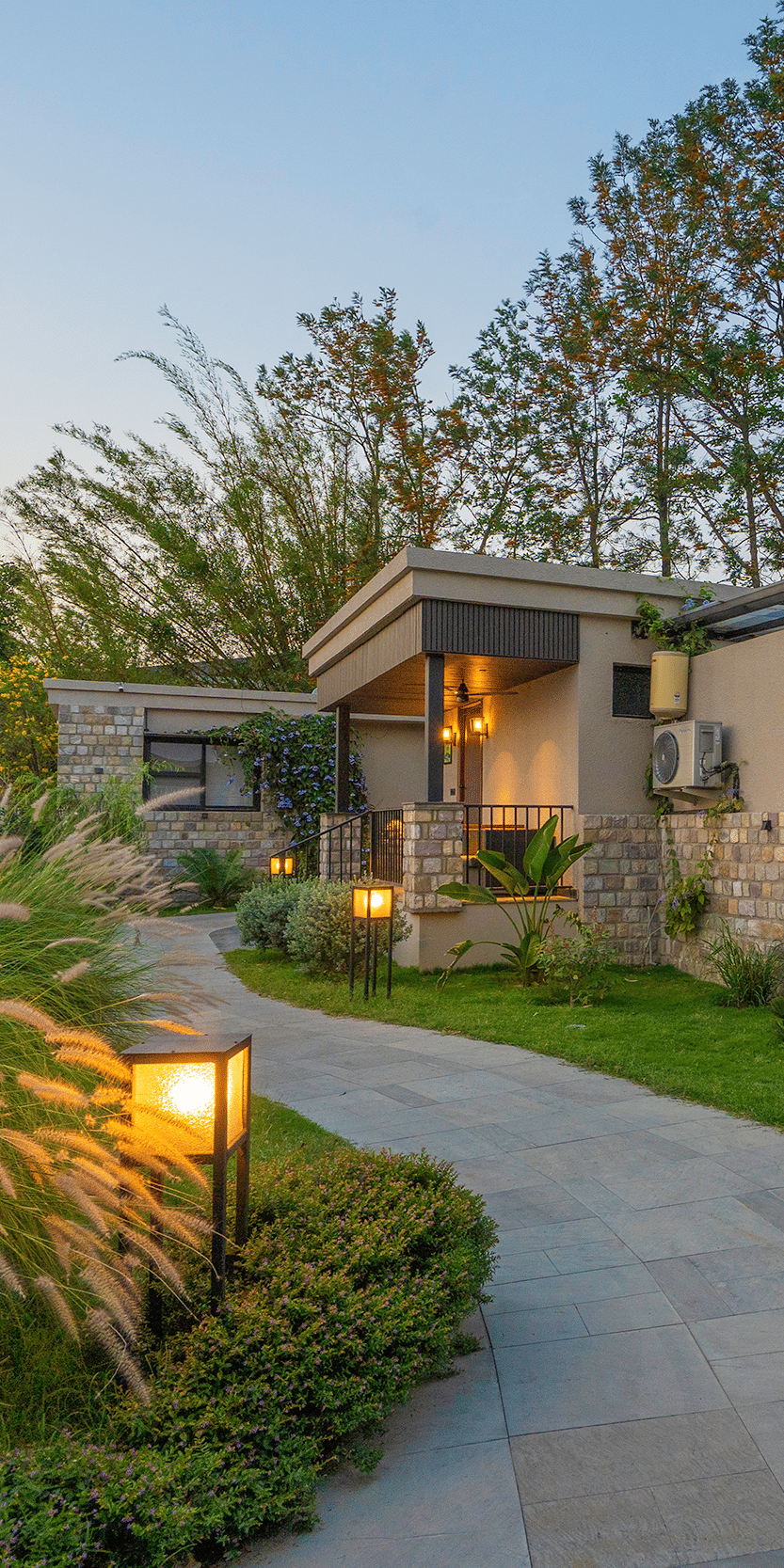 A paved pathway leading towards buildings in a landscaped area  at The Golden Tusk, Jim Corbett