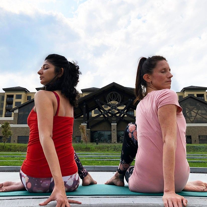 2 woman doing yoga poses during daytime