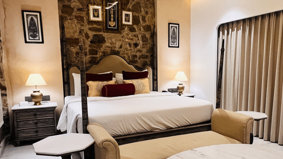Premium Deluxe Room bedroom at Juna Mahal, Ranthambore featuring king bed, ambient lighting, artwork and refined interiors