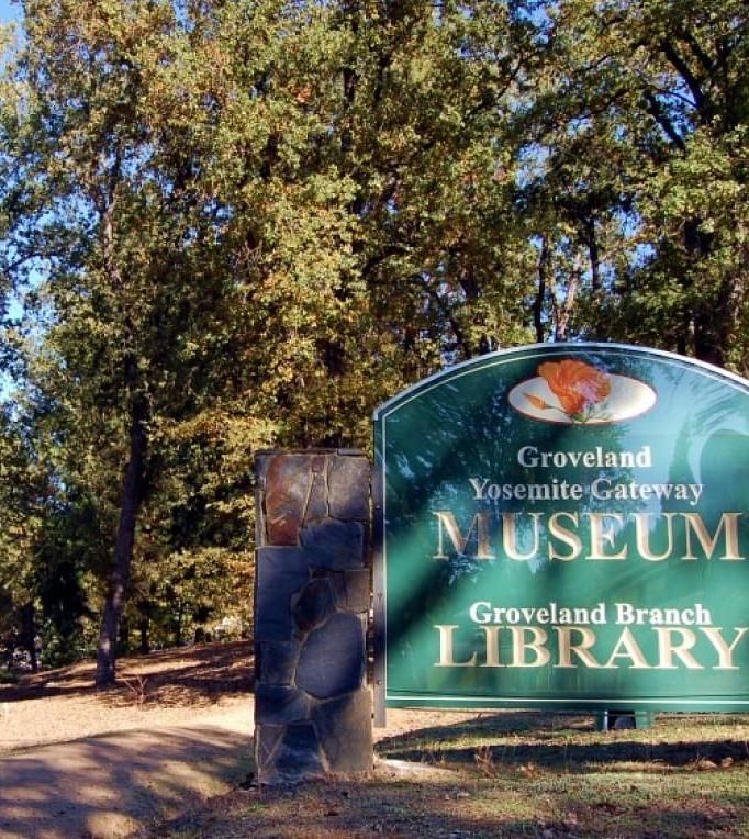 A sign reading Groveland Yosemite Gateway Museum and Groveland Branch Library - The Groveland Hotel.
