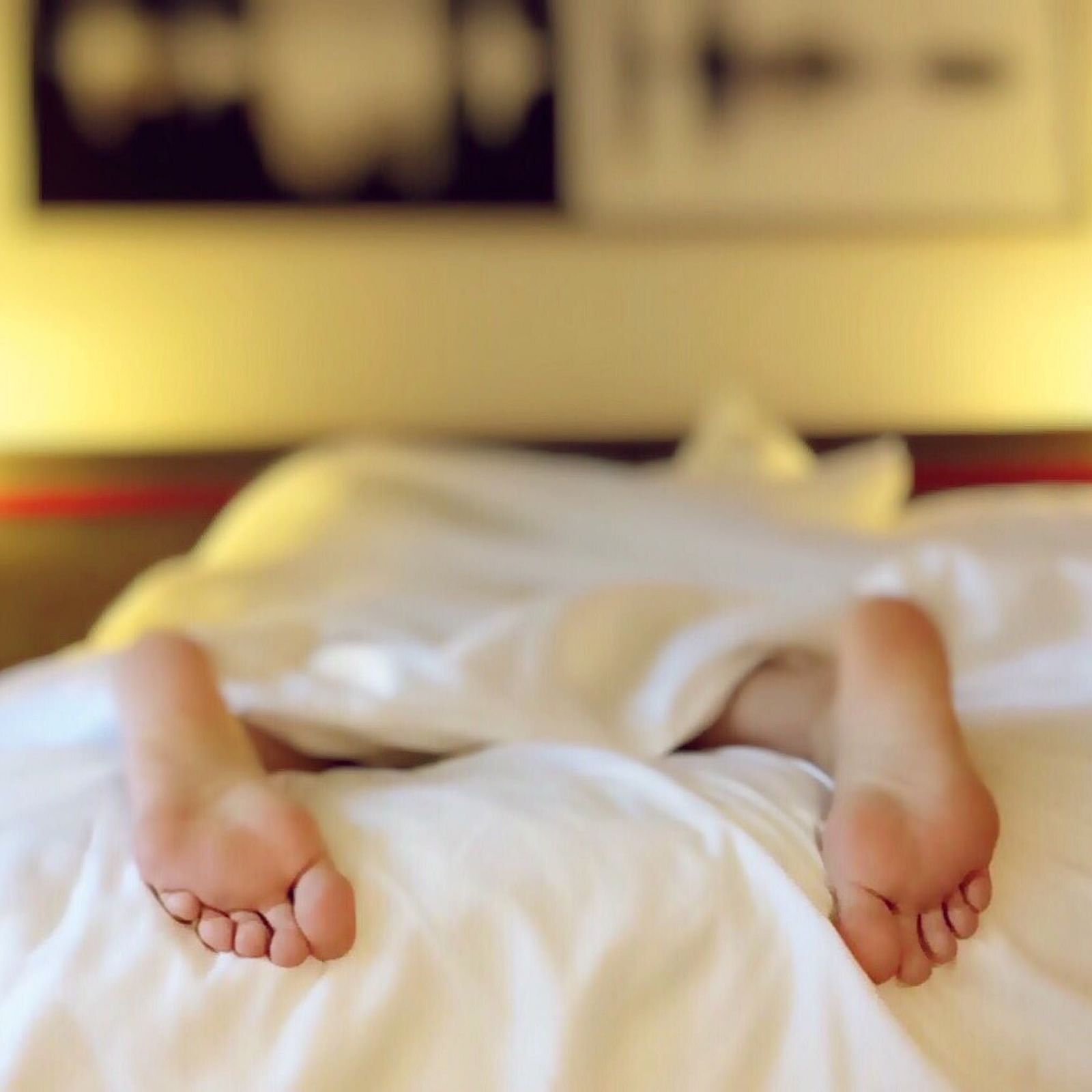 A person lying on the bed in a hotel room