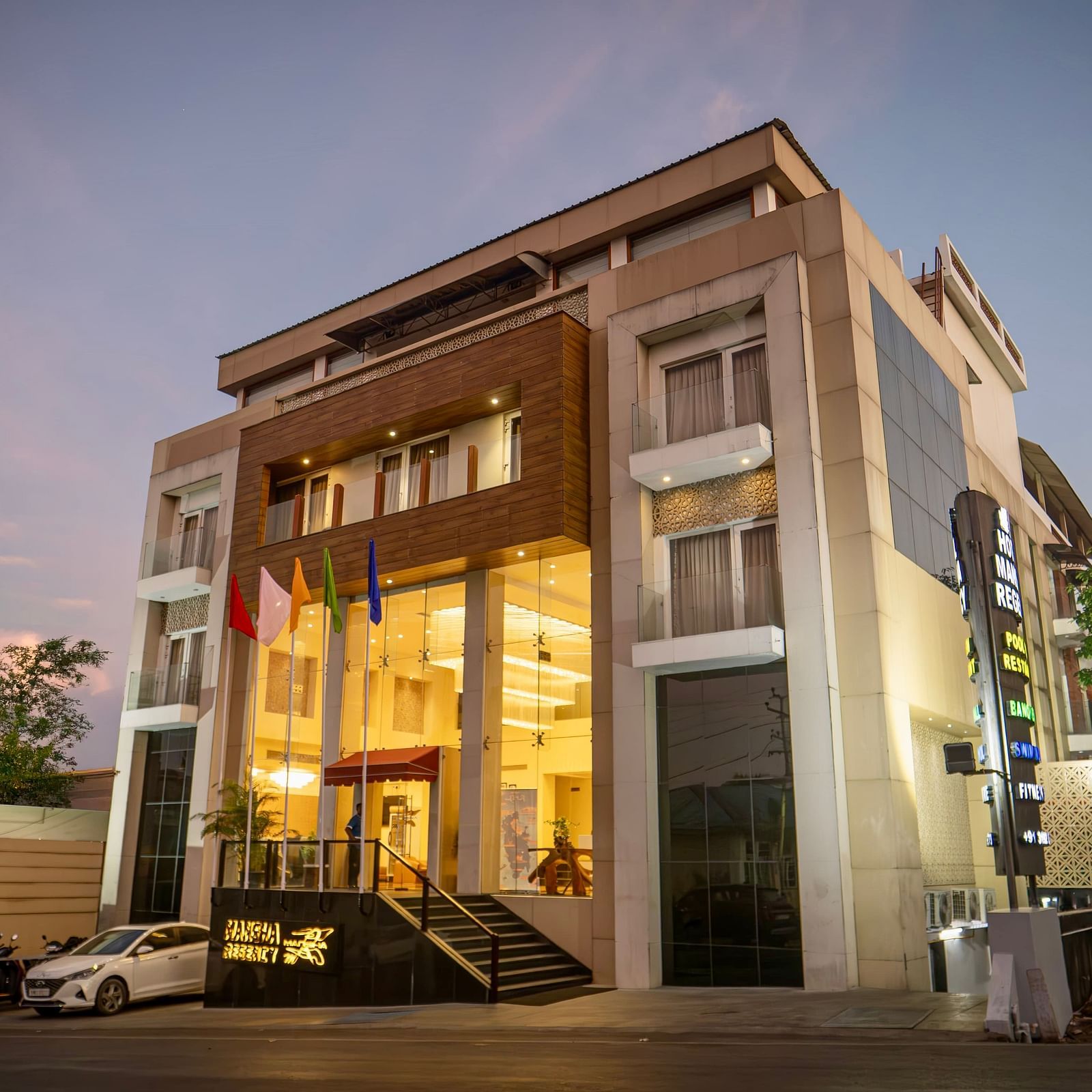 The exterior of Mansha Hotel Regency, a multi-storey building with a modern design, captured during early evening | Mansha Hotels